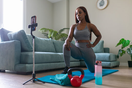 Woman exercising at home while recording a video
