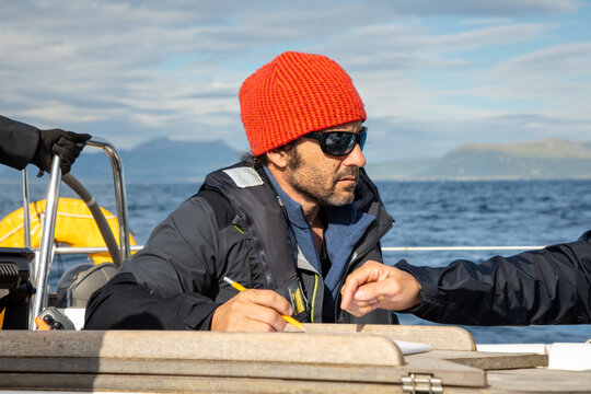 Sailor listens intently to companion aboard Lofoten vessel