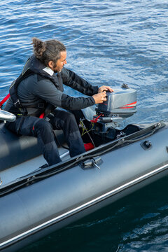 Man preparing motorboat engine on calm water