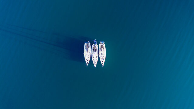 Aerial view of three sailboats on a calm sea in Norway