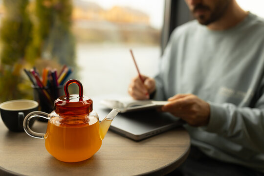 Student studying with tea in cozy cafe setting