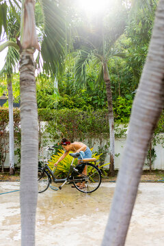 Woman cleaning her bicycle outdoors in a sunny garden
