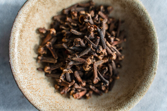 Aromatic cloves in rustic ceramic bowl for cooking