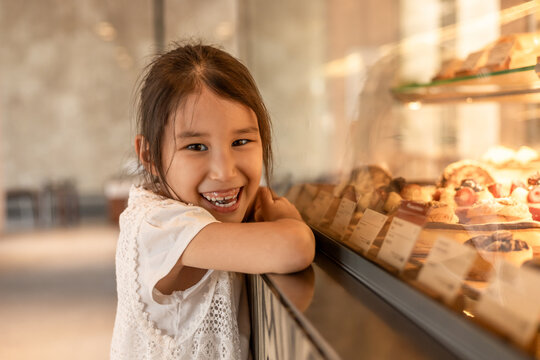 Girl smiling at bakery display with sweet pastries