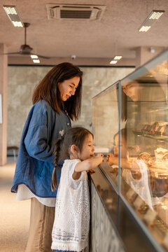 Mother and daughter enjoying a bakery display