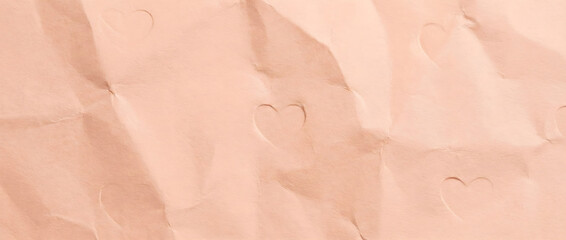 Fototapeta premium Crumpled pastel pink paper texture with embossed heart shapes. Wrinkled page background for Valentine's Day love letter concept