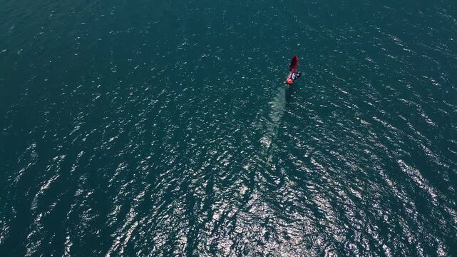 Aerial shot of a man windsurfing on Lake Potrerillos in Mendoza, Argentina