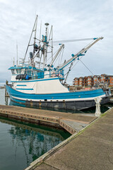 Fototapeta premium A blue and white commercial fishing trawler is docked at the marina in Westport, Washington, USA