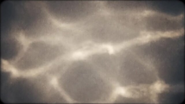 Ethereal Caustic Overlay Showcasing the film grain and caustic patterns as a standalone, atmospheric overlay that adds a layer of depth and vintage feel to any footage, focusing on its abstract