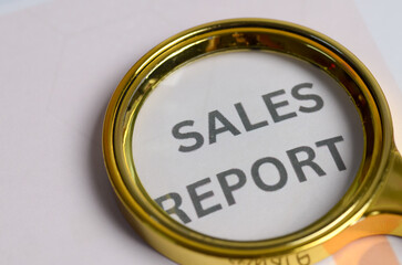 Fototapeta premium Scrutiny and Analysis of Sales Report with Magnifying Glass Highlighting Business Performance