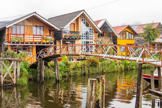 Alpine style houses stilt village lake reflection overcast day laguna de la cocha colombia
