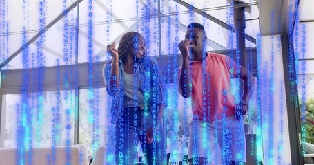 Naklejka premium Smiling couple standing chatting in bright atrium, in denim and coral polo with blue code overlay