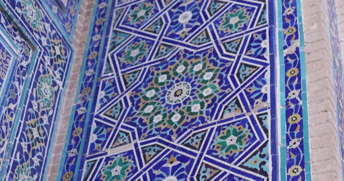 Decorative blue majolica tile pattern with intricate geometric and floral ornamentation. Close-up of traditional Islamic ceramic mosaic used in historic architecture.