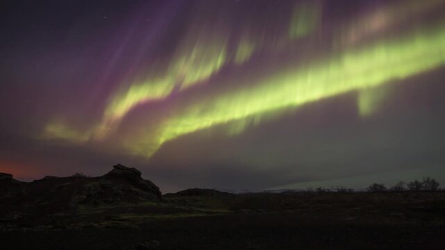 Brilliant multi colored aurora borealis over clouds Raudholar Iceland