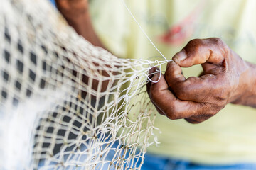 Artisanal fisherman hands repairing fishing net Caribbean Coast Colombia close-up © ricardo