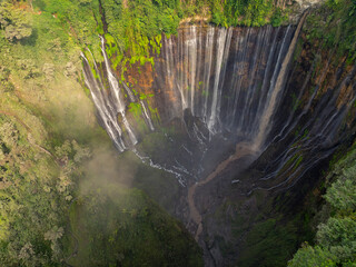 Obraz premium Top-Down Aerial View of Tumpak Sewu Waterfall Surrounded by Lush Tropical Forest, Indonesia