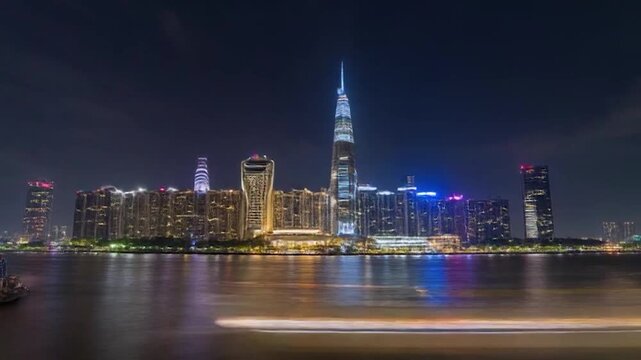 Nighttime cityscape of Dubai with illuminated skyscrapers and water reflection.
