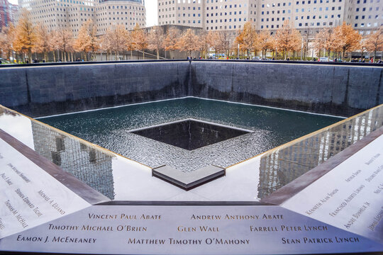 9/11 Memorial reflecting pools with victim names in New York City and Freedom Tower, poignant NYC site of remembrance in American history.
