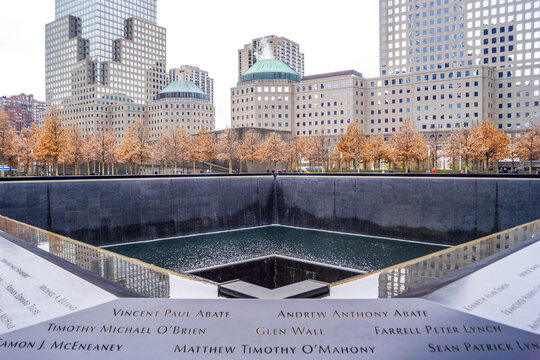 9/11 Memorial reflecting pools with victim names in New York City and Freedom Tower, poignant NYC site of remembrance in American history.
