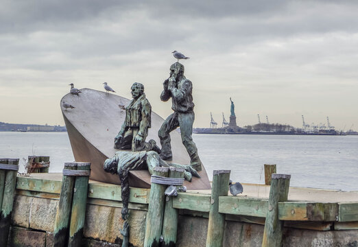 American Merchant Mariners Memorial sculpture by Marisol Escobar at Battery Park NYC, WWII U-boat victims on sinking ship with Statue of Liberty horizon.
