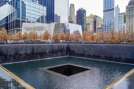 9/11 Memorial reflecting pools with victim names in New York City and Freedom Tower, poignant NYC site of remembrance in American history.
