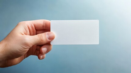 Obraz premium Professional hand holding white business card mockup for presentation and branding identity.