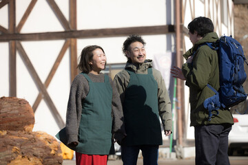 田舎で民宿やペンションを家族経営している接客や受付、チェックインの案内する夫婦と登山者　登山の山小屋などのイメージ　いらっしゃいませ