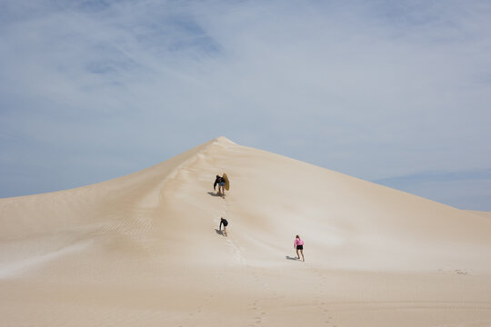 Kids climbing to top of sand dune in remote Australia