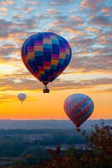 Naklejka premium Colorful hot air balloons ascend at sunrise over misty landscape