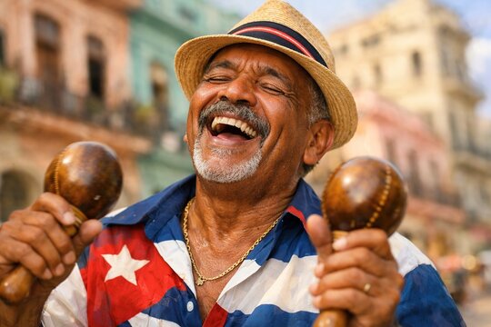 Cuban musician laughs while holding maracas in front of historic buildings.