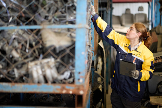 Worker examines metallic scrap inside a factory