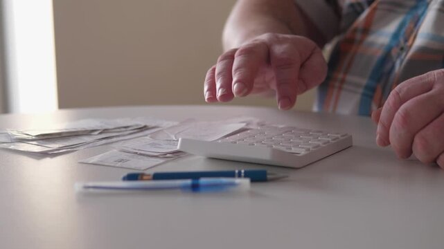 White Man Organizing Bills And Receipts At Desk With Calculator And Blue Pen, Steady Hands Sorting Payment Slips, Quiet Afternoon Light, Careful Planning Of Household Budget And Upcoming