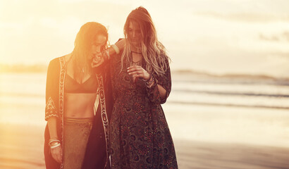 Women, outdoor and sunset on beach for holiday, adventure and boho fashion at sea. Friends, travel and space for summer vacation, ocean weekend and sunshine for reunion and trip together with flare © JamDay/peopleimages.com