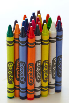 Colorful vibrant crayons standing upright in an assortment of colors in a vertical image