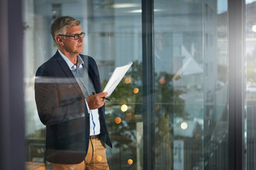 Documents, finance and ideas with business man in glass office for decision, planning or vision. Accounting, paperwork and window with mature person in financial workplace for investment management © BuyoutReese06/peopleimages.com