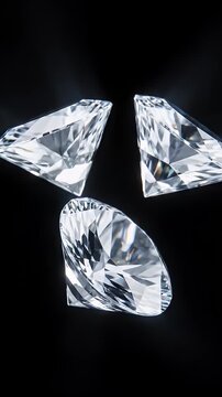 Three sparkling diamonds on a black background with dramatic lighting