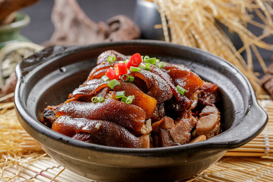 Braised pork knuckle in a black casserole dish