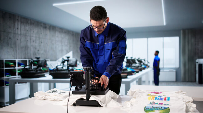 Young Man Operating Custom Digital Print T-shirt Press Machine
