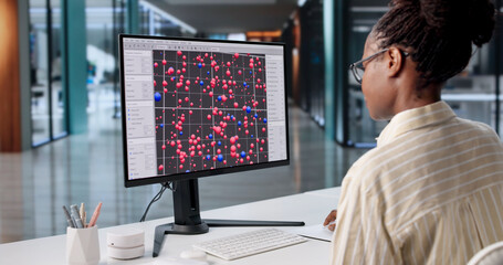 Hardworking African American Woman Analyzing Big Dataset On Office Computer