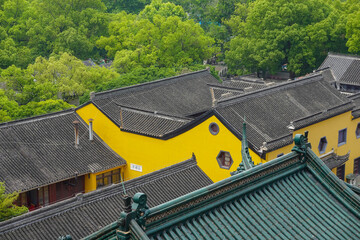 Warm yellow plaster wall with traditional roof above © SILI