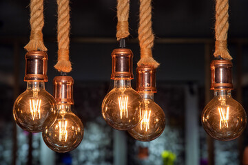 Vintage Edison bulbs with strings, warm ambient lighting and rustic decor. Hung from thick ropes, they create a cozy atmosphere. © Harold