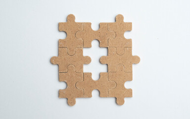 Obraz premium Empty wooden puzzle on a clean white background with copy space, suitable for advertising concepts, branding, marketing messages, and creative design.
