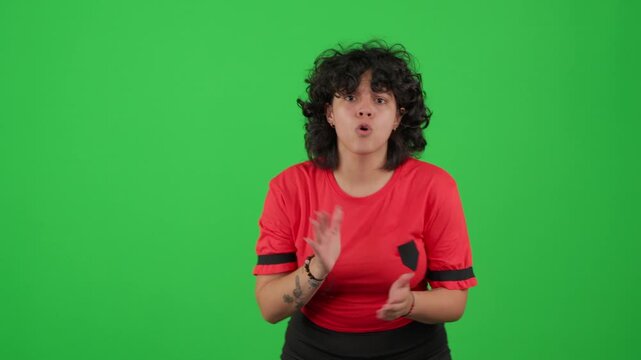 passionate young woman clapping and cheering in front of a green screen