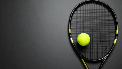 Tennis racket with ball on dark surface