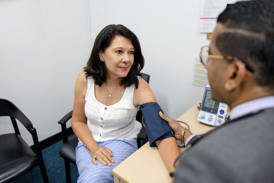 Doctor holding the cuff on senior woman's arm