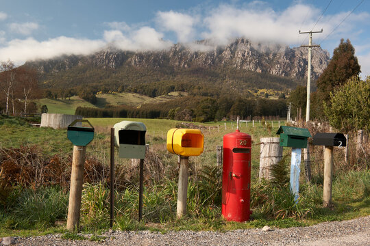 Rural letterboxes in front of cloudy mountain.