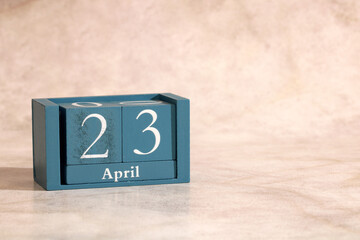 Wooden block calendar showing April 23 date