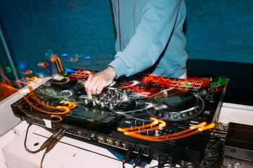 Naklejka premium Dj mixing music on controller at nightclub party
