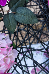 Detail from hanging chair decorated with artificial flowers