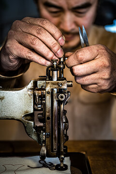 ハンドルミシンを調整する刺繍職人